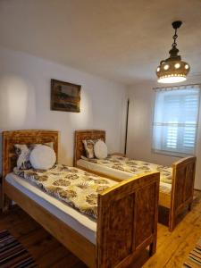 2 camas individuais num quarto com um lustre em FLORESTI HOUSE 21 em Roandola