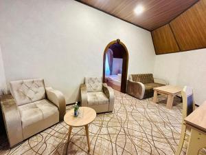 a living room with chairs and a table and a mirror at Cinema Boutique Hotel in Ganja