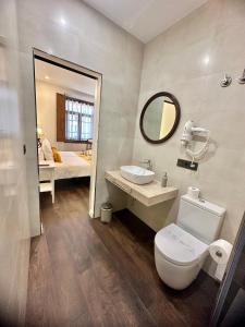 uma casa de banho com um WC, um lavatório e um espelho. em CLAREN´S BOUTIQUE ROOMS em Cangas del Narcea