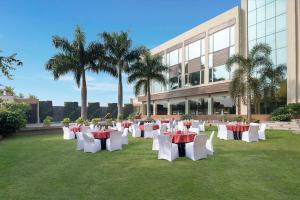 a group of tables and chairs on the grass in front of a building at Country Inn & Suites By Radisson Jammu in Jammu