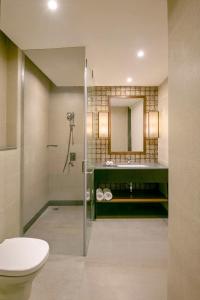 a bathroom with a shower and a toilet and a sink at Country Inn & Suites By Radisson Jammu in Jammu