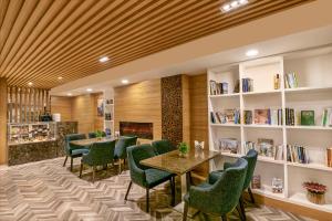 a restaurant with green chairs and tables and a fireplace at Country Inn & Suites By Radisson Jammu in Jammu