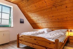 Cama en habitación con techo de madera en 50044..., en Carolinensiel