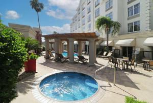 - une piscine avec un kiosque, des tables et des chaises dans l'établissement Wyndham Garden McAllen at La Plaza Mall, à McAllen