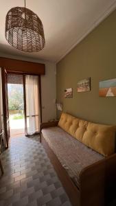 Drè Marèna في ريميني: غرفة نوم مع أريكة كبيرة في غرفة مع نافذة
