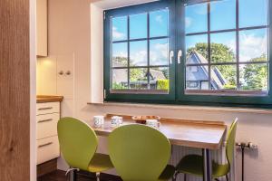a kitchen with a table and chairs and a window at 50043... in Carolinensiel