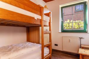 1 Schlafzimmer mit 2 Etagenbetten und einem Fenster in der Unterkunft 50043... in Carolinensiel