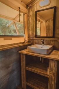 a bathroom with a sink and a mirror at Hluhluwe Bush Camp in Hluhluwe +86 photos