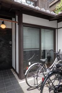 Duas bicicletas estacionadas à porta de um edifício. em KyoMachiya Stars em Quioto
