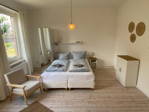 ein Schlafzimmer mit 2 Betten und einem Stuhl darin in der Unterkunft Villa Rysum in Krummhörn