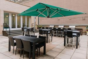 a patio with tables and chairs and a green umbrella at Streeterville Studio w Deck Pool nr Beach CHI-583 in Chicago
