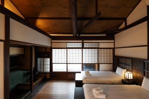 Un dormitorio con dos camas y una gran ventana. en KyoMachiya Stars, en Kioto 37 fotos más