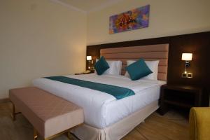 a bedroom with a large white bed with blue pillows at Best Western Premier Dynasty in Addis Ababa