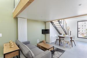 una sala de estar con un sofá y una mesa en Le Saint Martin 1 - Appt moderne et confortable, en Rennes