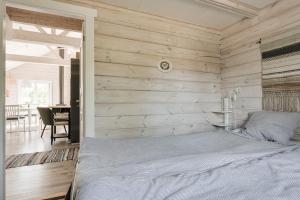 1 dormitorio con 1 cama y pared de madera en Seaside holiday home in Axmar north of Gavle, en Bergby