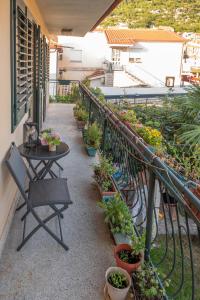 - un balcon avec une table et un bouquet de plantes en pot dans l'établissement Apartman Platan, à Metković