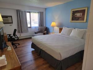 Habitación de hotel con cama grande y escritorio. en SureStay by Best Western Glendive Yellowstone River en Glendive