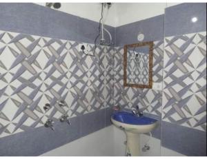 a blue and white bathroom with a sink and a mirror at Fogg Valley, Banikhet Jangal in Banikhet
