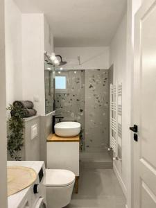 a white bathroom with a toilet and a sink at Genesis - Iasi City Center in Iaşi