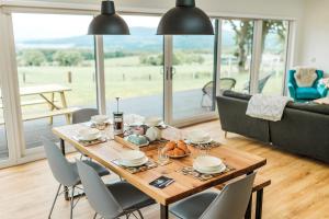 a dining room with a table and chairs and a couch at Cairn Dyke Lodge in Gatehouse of Fleet