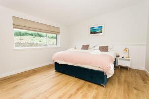 a white bedroom with a bed and a window at Cairn Dyke Lodge in Gatehouse of Fleet