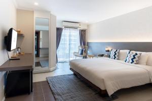 1 dormitorio con 1 cama grande y espejo en Heeton Concept Hotel Pattaya by Compass Hospitality en Pattaya Central