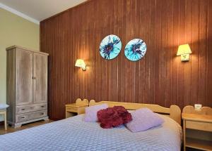 um quarto com uma cama com três pratos na parede em Ierullē em Alūksne