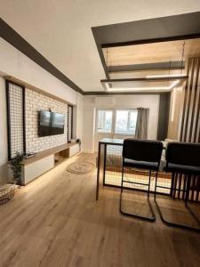 uma sala de estar com uma mesa e cadeiras e uma televisão em Genesis - Iasi City Center em Iaşi