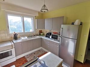 a kitchen with a stainless steel refrigerator and a sink at La Maison du Verger in Sainte-Foy