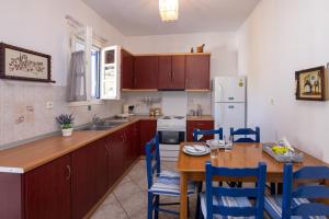 a kitchen with a wooden table and blue chairs at Tinos 2 bedrooms 5 persons apartment by MPS in Khatzirádhos