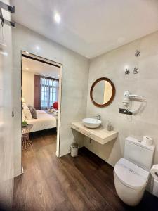 Un baño con inodoro, lavabo y espejo. en CLAREN´S BOUTIQUE ROOMS, en Cangas del Narcea