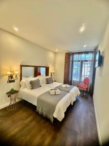 Un dormitorio con una cama grande y una ventana grande. en CLAREN´S BOUTIQUE ROOMS, en Cangas del Narcea