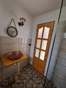 uma casa de banho com um lavatório de madeira e um espelho em FLORESTI HOUSE 21 em Roandola