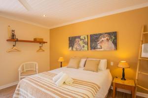 a bedroom with a bed and two pictures on the wall at bWhale guest house in Knysna