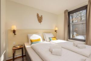 1 dormitorio con 2 camas blancas y ventana en Center Parcs Huttenheugte Drenthe-Overijssel, en Dalen