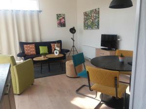 - un salon avec une table et des chaises dans l'établissement Vakantie Huisje nabij Leeuwarden en Friese kust, à Dronrijp
