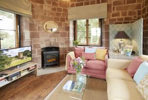 a living room with a pink couch and a fireplace at Knoll Tower in Shifnal