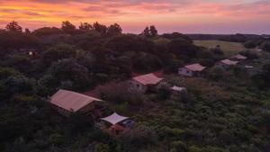 widok z powietrza grupy domów w polu w obiekcie Hluhluwe Bush Camp w mieście Hluhluwe