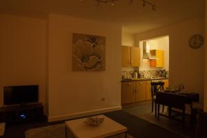 a living room with a table and a kitchen at Urban Chic Suite - Simple2let Serviced Apartments in Halifax