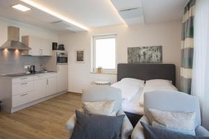 een woonkamer met een bed en 2 witte stoelen bij Appartement Brink Fichtenweg 26 in Winterberg
