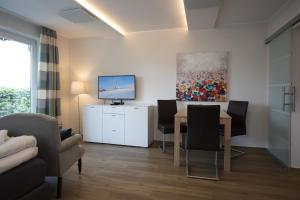 een woonkamer met een tafel en stoelen en een televisie bij Appartement Brink Fichtenweg 26 in Winterberg