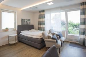 een slaapkamer met een bed, een bank en ramen bij Appartement Brink Fichtenweg 26 in Winterberg