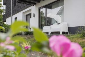 twee witte stoelen buiten een huis bij Appartement Brink Fichtenweg 26 in Winterberg