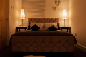 Urban Chic Suite - Simple2let Serviced Apartments في هاليفاكس: غرفة نوم بسرير كبير فيها مصباحين