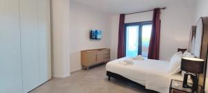 um quarto com uma cama branca e uma janela em Marisabella Suite Spa 5 em Bari