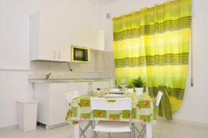 a kitchen with a table with a yellow curtain at DELPOSTO Marina di Ragusa (sd) in Marina di Ragusa
