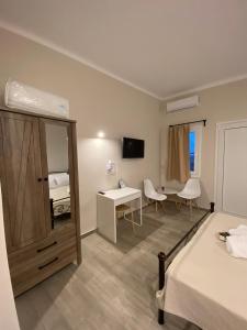 a hotel room with a bedroom with a bed and a desk at Elia Apartments in Agia Marina Aegina