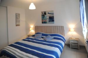 ein Schlafzimmer mit einem blau-weißen gestreiften Bett in der Unterkunft Résidence Les Océanes in Les Sables-dʼOlonne