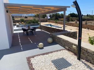 eine Terrasse mit einem Tisch und Stühlen unter einem Pavillon in der Unterkunft Bluebell Resort Villa SUNRISE in Kampos Paros