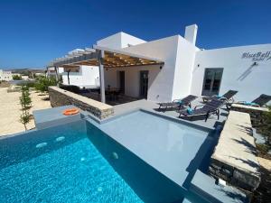 eine Villa mit einem Pool vor einem Haus in der Unterkunft Bluebell Resort Villa SUNRISE in Kampos Paros